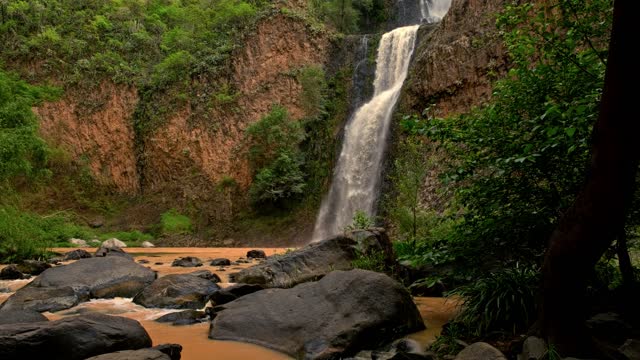Lush waterfall cascading over rocks in a forest setting.