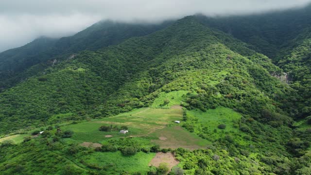 Lush Green Mountains Under Cloudy Skies.