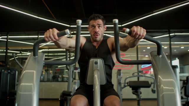 Man exercising on chest press machine in gym.
