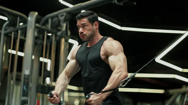 Man performing cable fly exercise in gym..