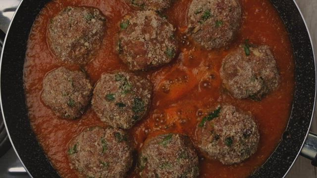 Cooking meat balls in sauce.