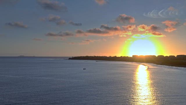 Sunset behind the skyline on the beach over the sea.